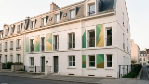 Immeuble résidentiel français rénové, avec une façade claire, des fenêtres modernes et des éléments visuels abstraits évoquant une amélioration de la performance énergétique.